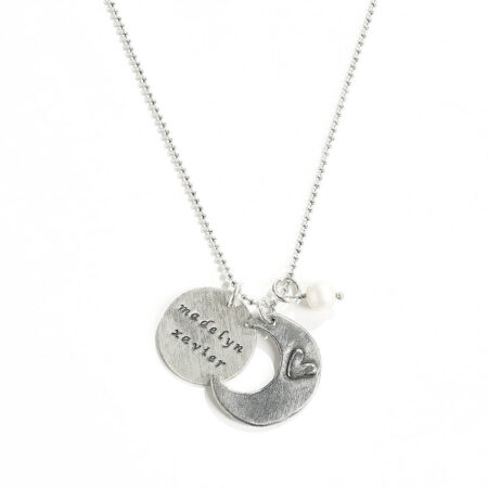 A moon charm hand stamped with “I love you to the moon and back” on one side and a heart on the other. Personalize necklace with names on the disc