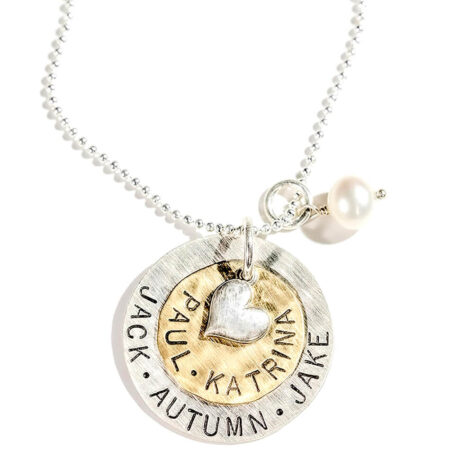A large sterling silver disc layered with a brass disc and topped with a silver heart. Hand stamped jewelry gift for mom, grandma