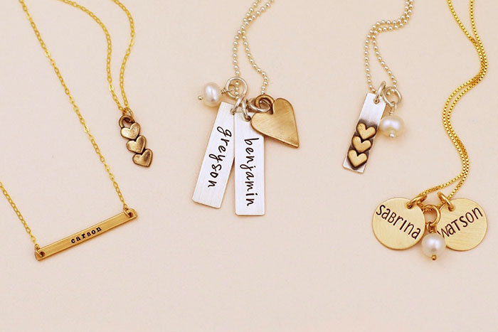 Displaying Sterling Silver and Gold Jewelry pieces personalized with names, initials, heart charms, pearls.