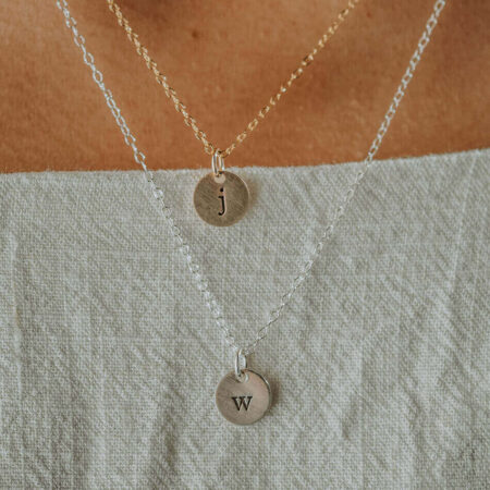 Hand-stamped initial on a tiny disc. Available in sterling silver or gold. Great personalized jewelry for wife, mom, new mom